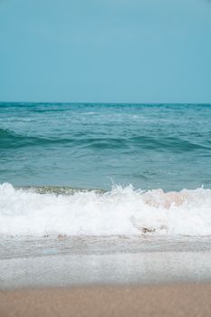 Dynamic ocean waves splash on a serene sandy beach, capturing the essence of coastal nature.