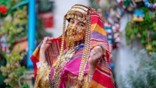 Free A woman in vibrant traditional Tunisian clothing posing in Hammamet, Tunisia. Stock Photo