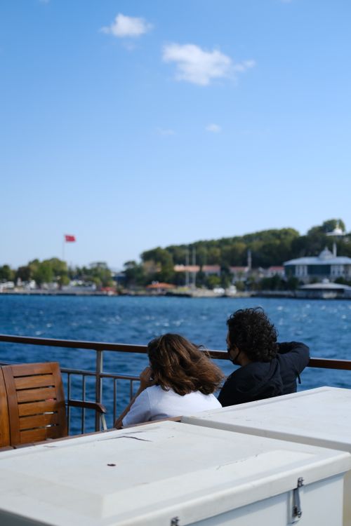 Free A couple enjoys a scenic ferry ride overlooking the Bosphorus in İstanbul, Türkiye. Stock Photo