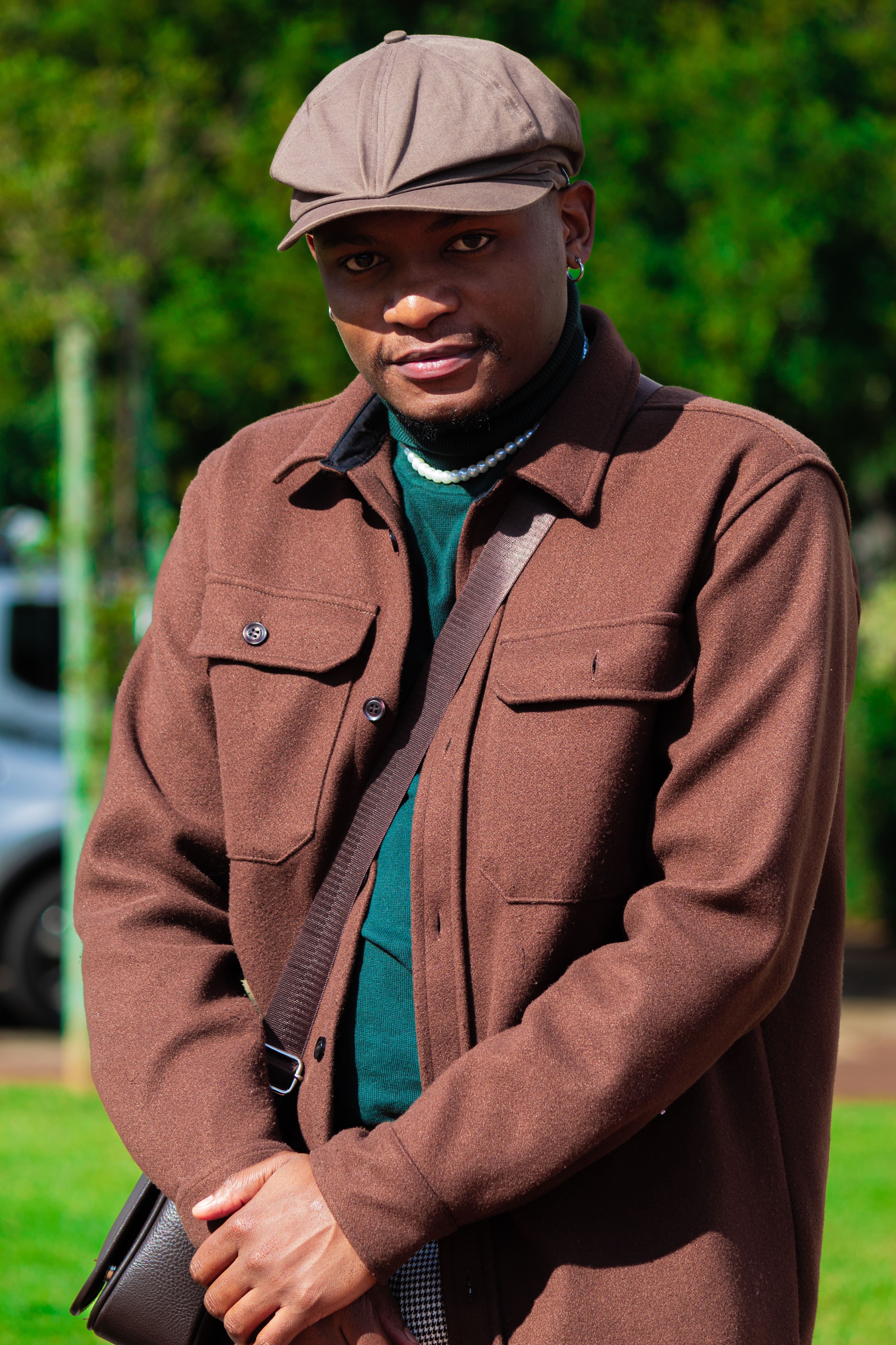 Fashionable man in a brown coat posing outdoors with natural light