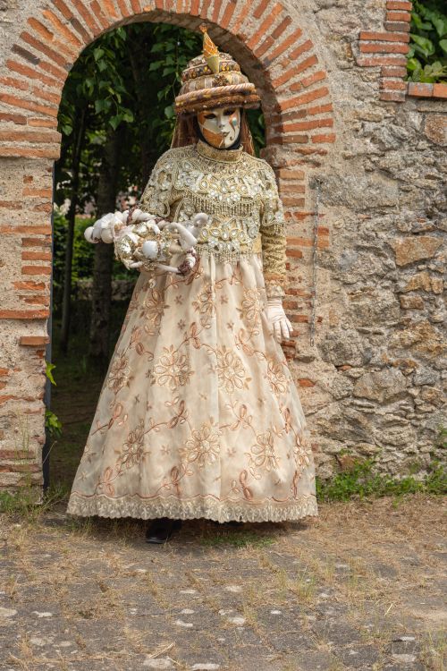 Free Woman in an elaborate costume and mask posing outdoors in Clisson, France. Stock Photo