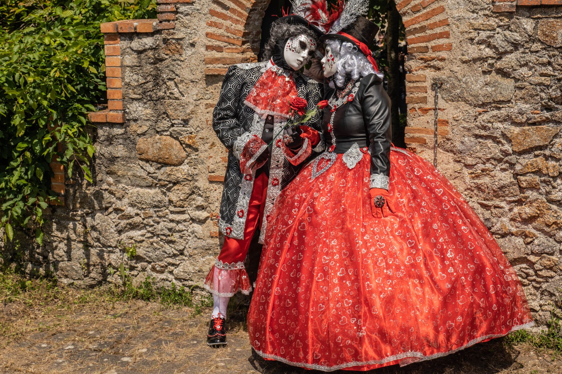Woman and Man Posing in Aristocrats Costumes by Stone Wall