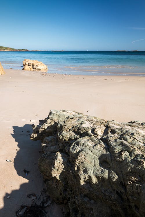 Boulders Lying on a Beach under Blue Sky 