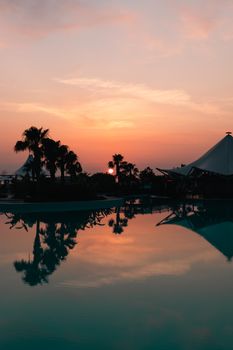 Sunset reflecting on a tranquil pool at a tropical resort in Didim, Türkiye.