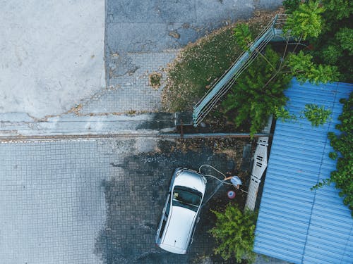 Top View of a Man Washing His Car by the Garage 