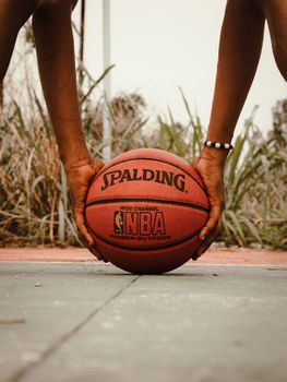 Capturing the intensity of basketball with close-up hands on Spalding ball outdoors.