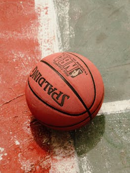 A Spalding basketball on a colorful outdoor street court, showcasing vibrant sports culture.