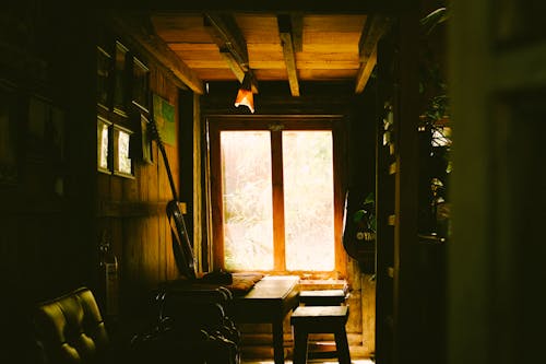 A Guitar Standing on a Table by the Window in a Room 