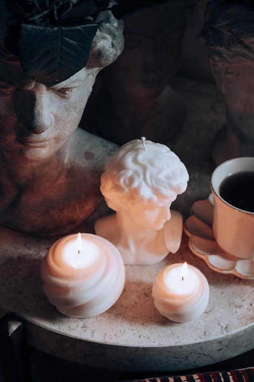 Candles and Sculptures by Cup of Coffee