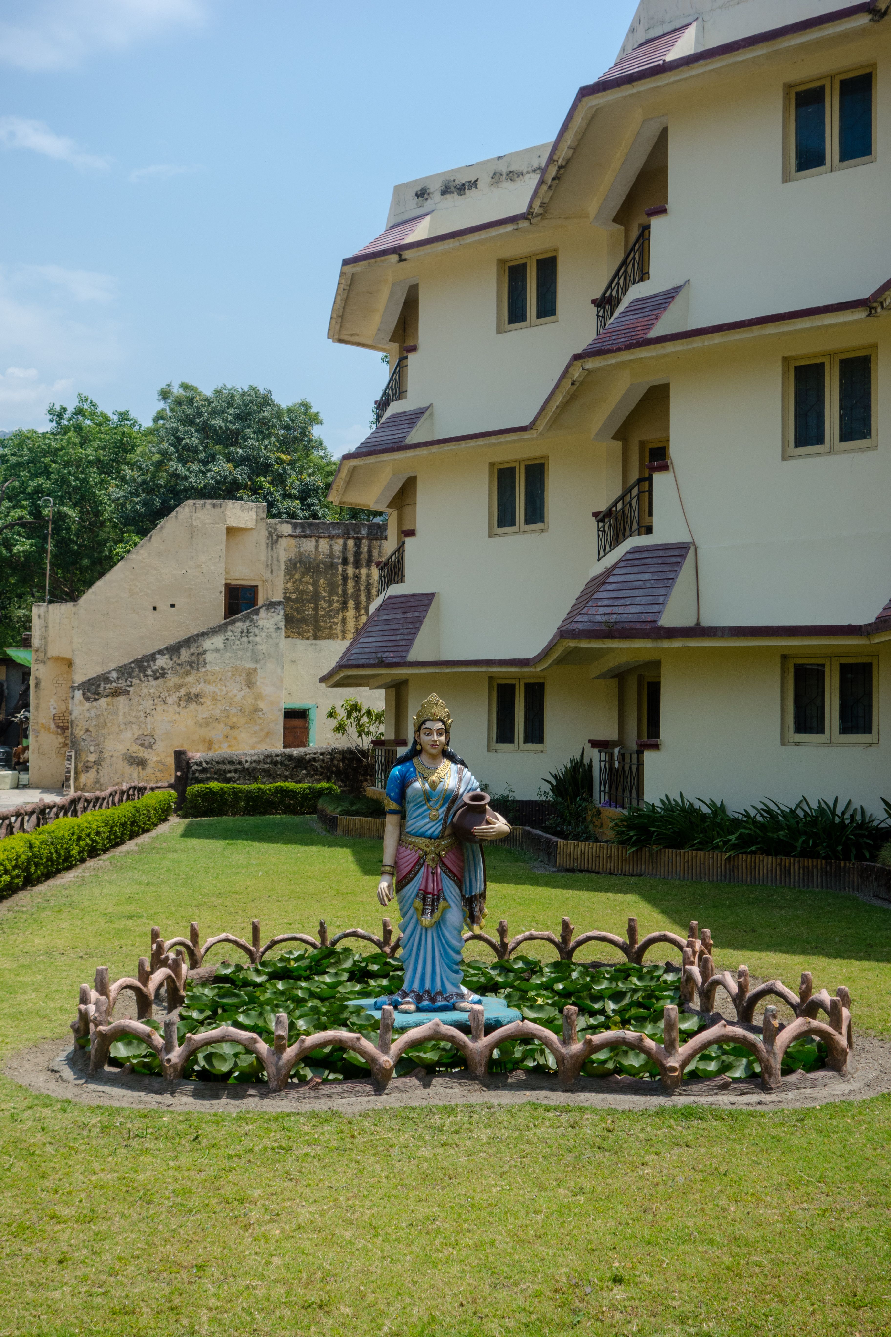 A serene statue in a well-maintained courtyard of a residential building complex.