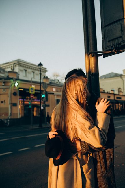 A couple embracing warmly on a city street during sunset, capturing a tender moment.