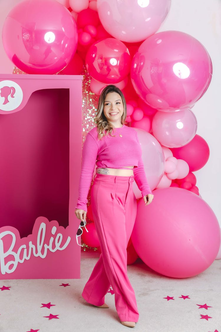 Woman Standing In Front Of Barbie Box And Pink Balloons 