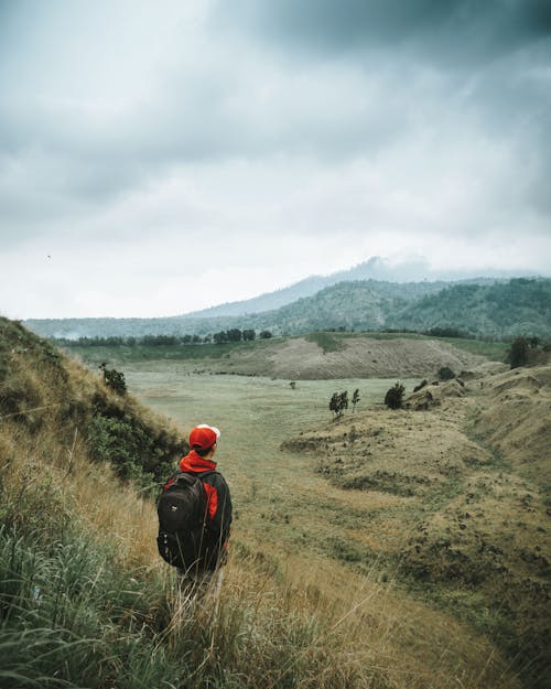 Landscape Photo of Man Facing Brown Mountain