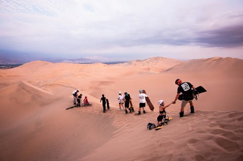 People with Sandboards on Desert