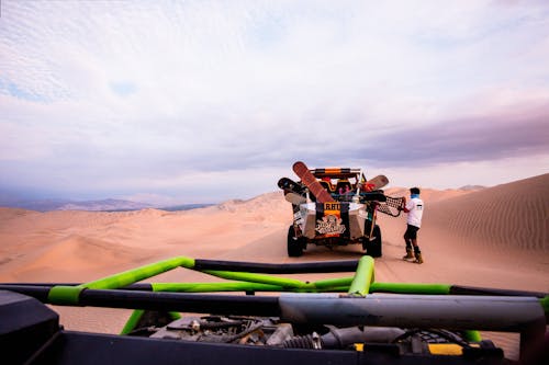 Man Standing by Buggy on Desert