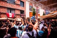 A lively crowd cheering with flags in Lima, Peru, showcasing cultural celebration and community spirit.