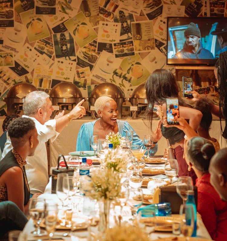 Smiling Family Sitting By Table