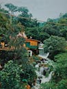 在热带森林中，宁静的瀑布流经乡村房屋，展现了大自然的美丽