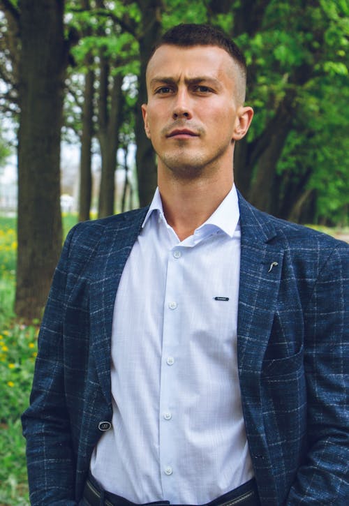 Short Haired Man in Blue Checked Suit Posing in a Park