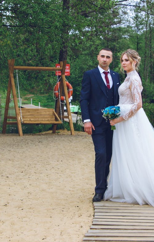 Newlyweds Standing and Posing near Sand