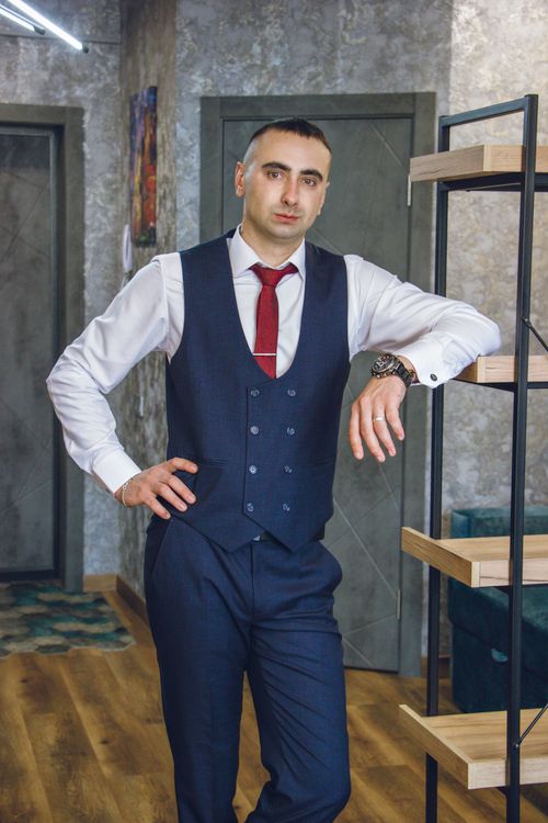 Free Well-dressed businessman posing in a modern office setting with a confident posture. Stock Photo