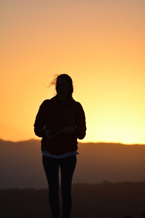 Foto De Silueta De Mujer De Pie Durante La Hora Dorada