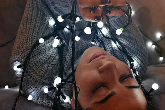 一位女子的室内肖像被发光的串灯环绕，传递出温暖与节日的氛围