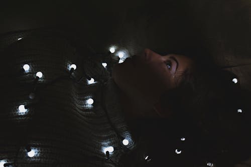 Woman Wrapped With Blanket and String Lights