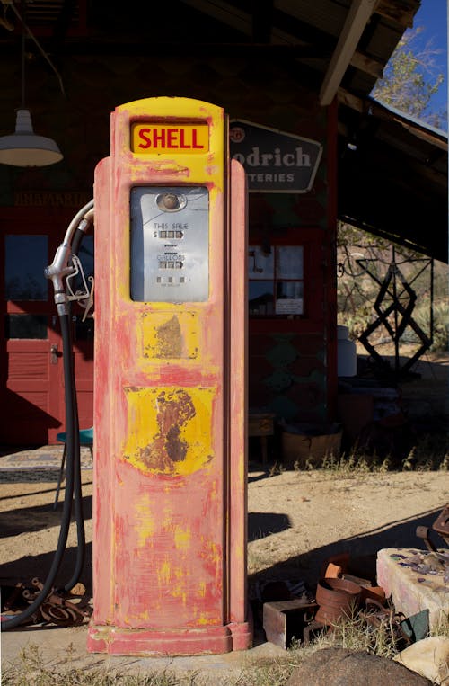 A vintage gas pump sits in front of a building