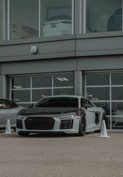 Professional photo of a black Audi R8 parked outside a modern building, perfect for urban and automotive themes.