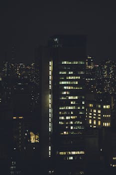 A nighttime cityscape featuring illuminated skyscrapers in a vibrant urban setting.