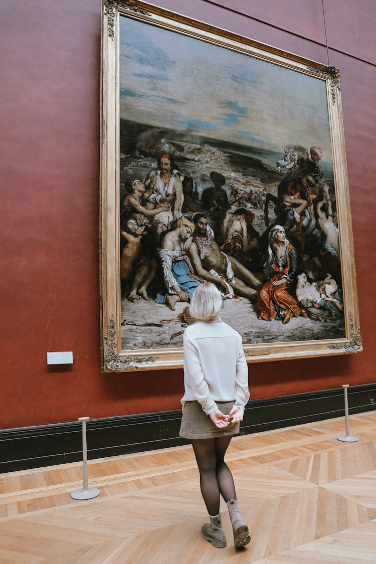 Woman In A Museum Looking At Paintings 