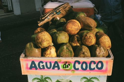 Free Street vendor cart filled with fresh coconuts at a Cartagena market, offering coconut water. Stock Photo
