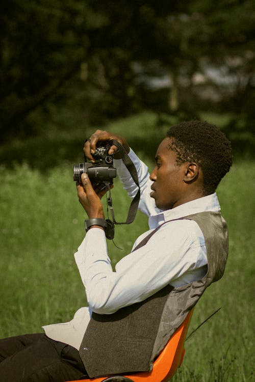 Man in Shirt Sitting with Camera