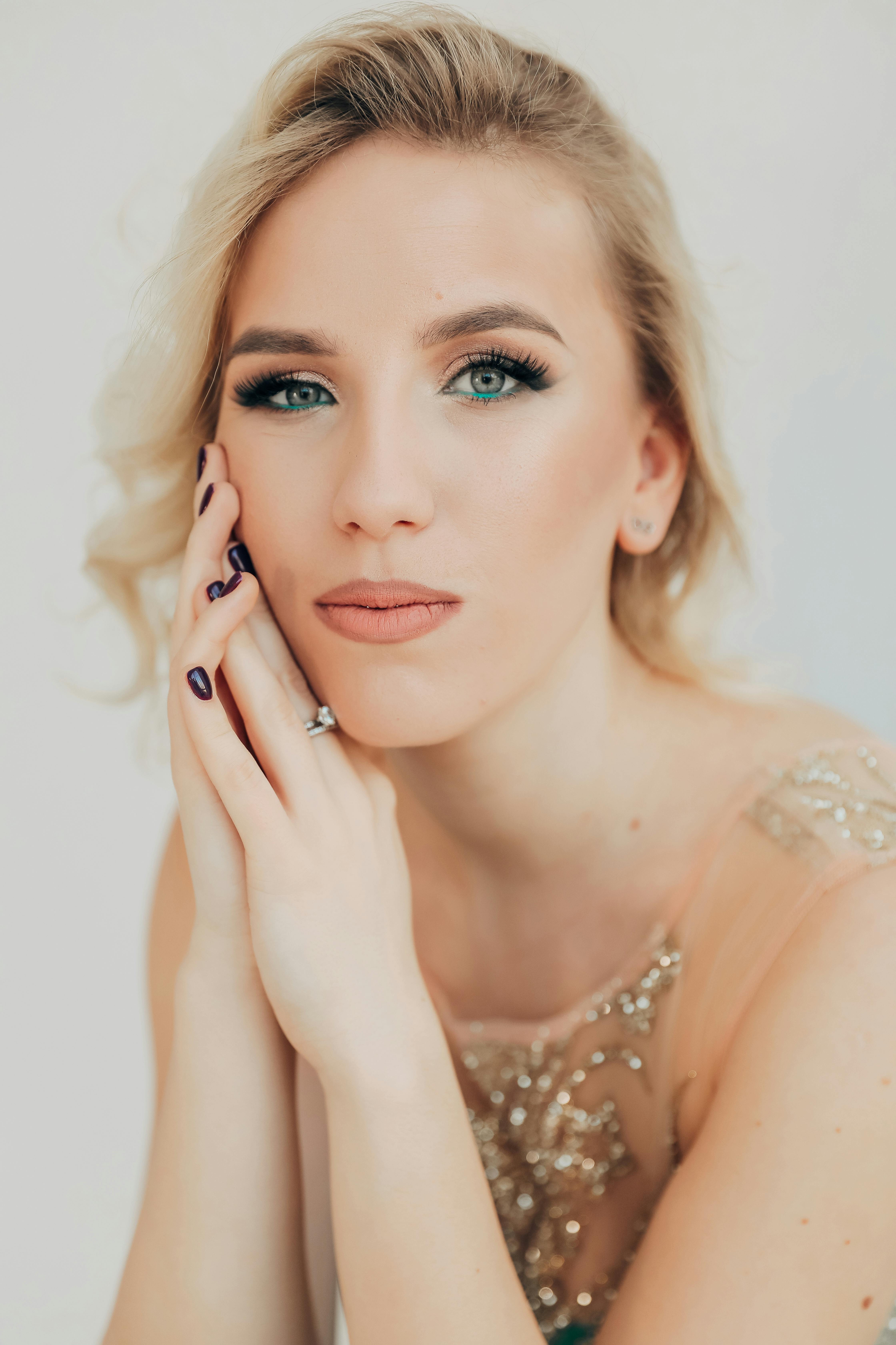 Stunning portrait of a blonde woman in evening wear with captivating eyes, perfect for fashion themes.