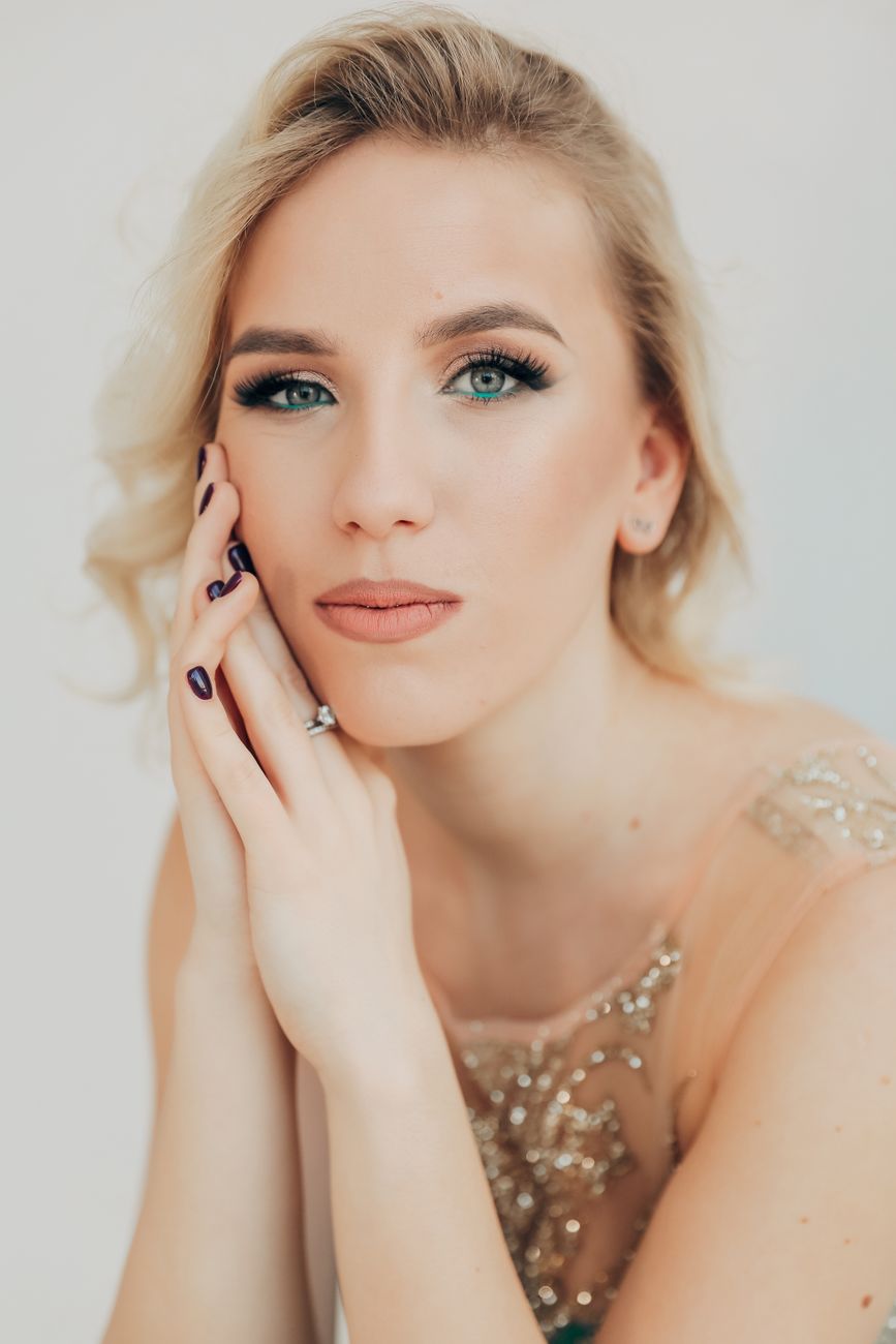 Stunning portrait of a blonde woman in evening wear with captivating eyes, perfect for fashion themes.