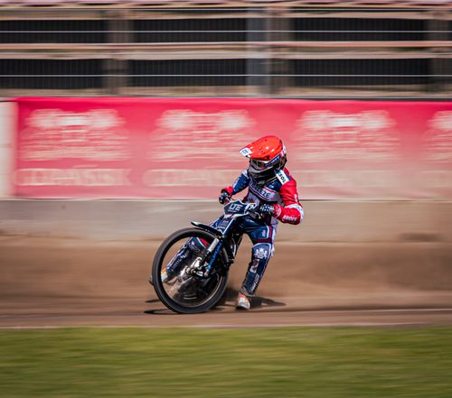 Free Dynamic shot of a motorcycle racer leaning into a turn on a dirt track, showcasing speed and skill. Stock Photo