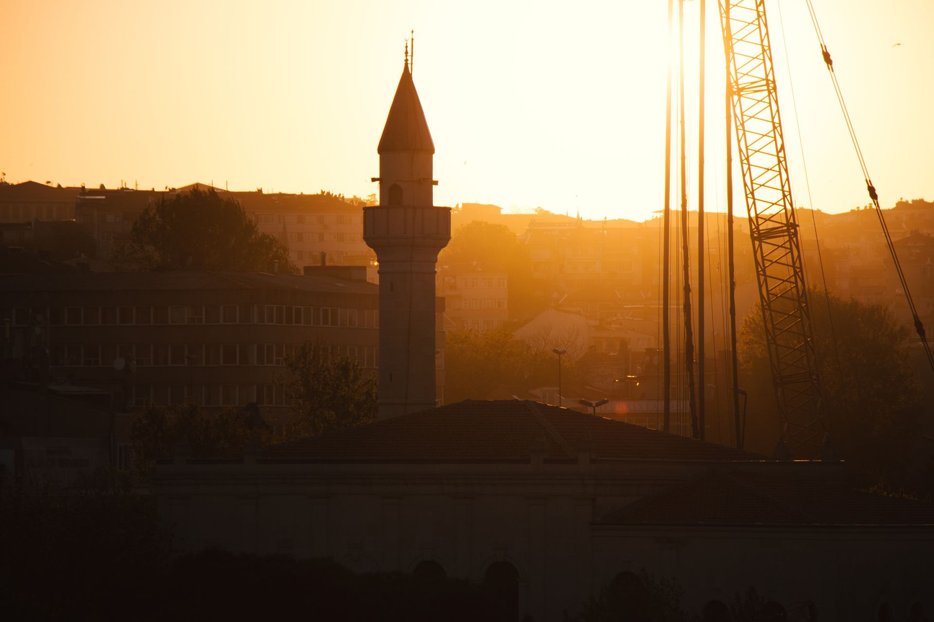 Silhouette of a construction crane at sunrise