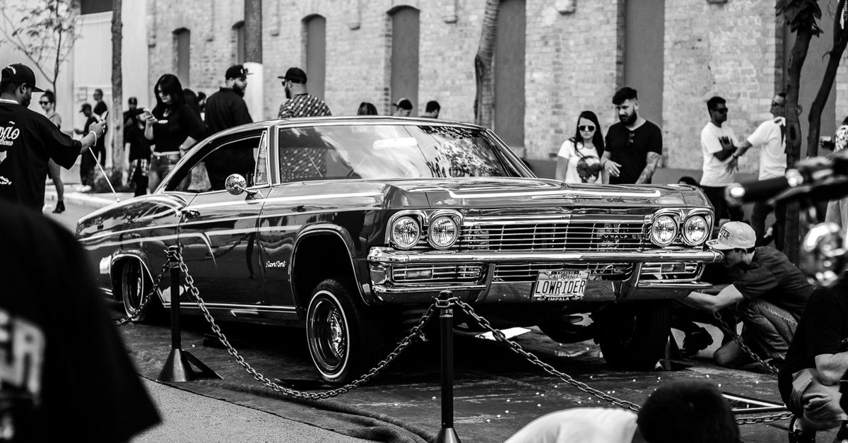 Vintage car with onlookers at a São Paulo street event. Classic vibes.