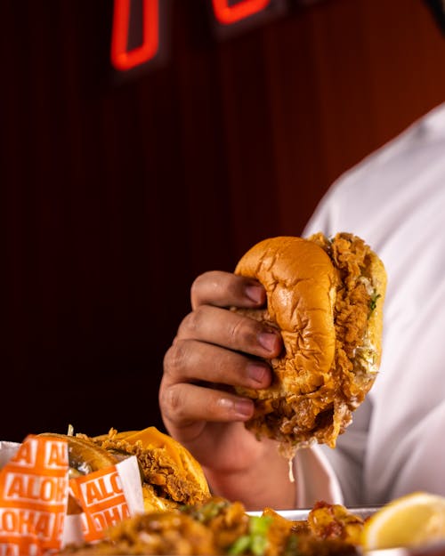 Tasty Burger with Fried Chicken in Hand