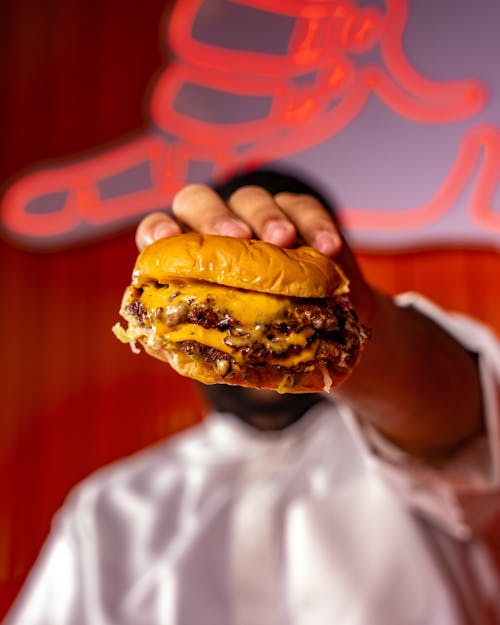 Free Delicious Burger with Cheese in Hand Stock Photo