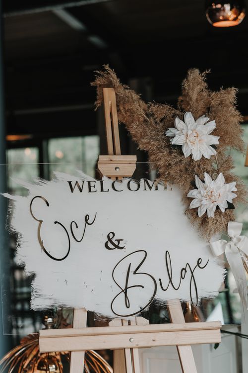 Free A stylish wedding welcome sign with flowers on an easel, perfect for romantic events. Stock Photo
