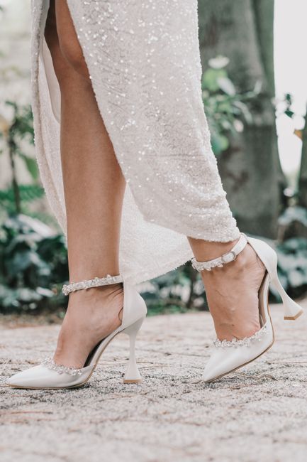 Close-up of a bride's elegant high heels and dress outdoors, perfect for a fashion-forward wedding.