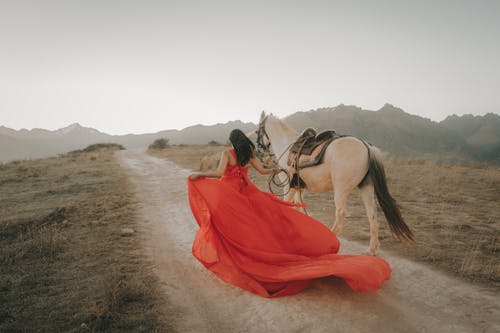Woman in Long Dress with Horse in Mountains