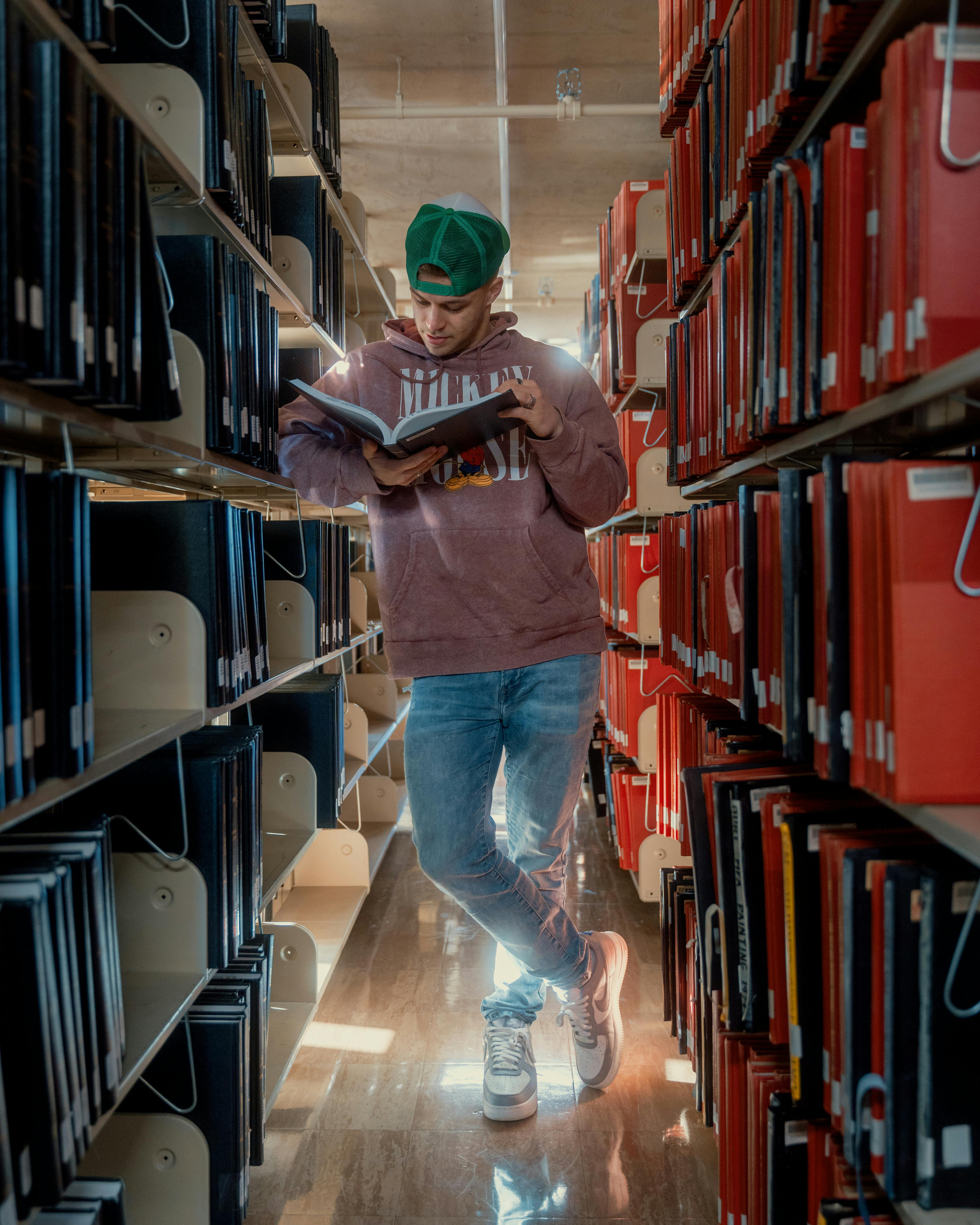 Free Man Reading Book In Library Stock Photo