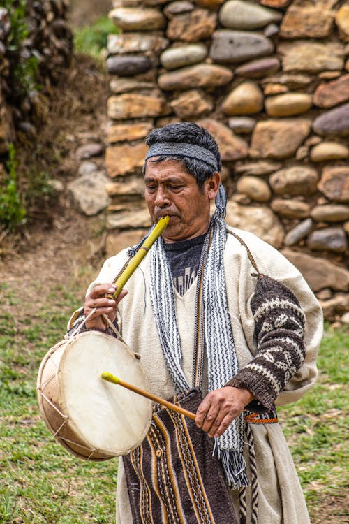 Elderly Man Playing Traditional Drum and Flute