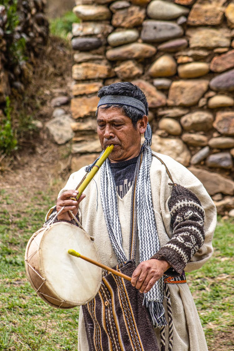 Elderly Man Playing Traditional Drum And Flute