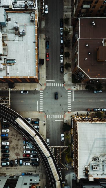Drone shot capturing a bustling city intersection in Chicago with visible train tracks and cars.