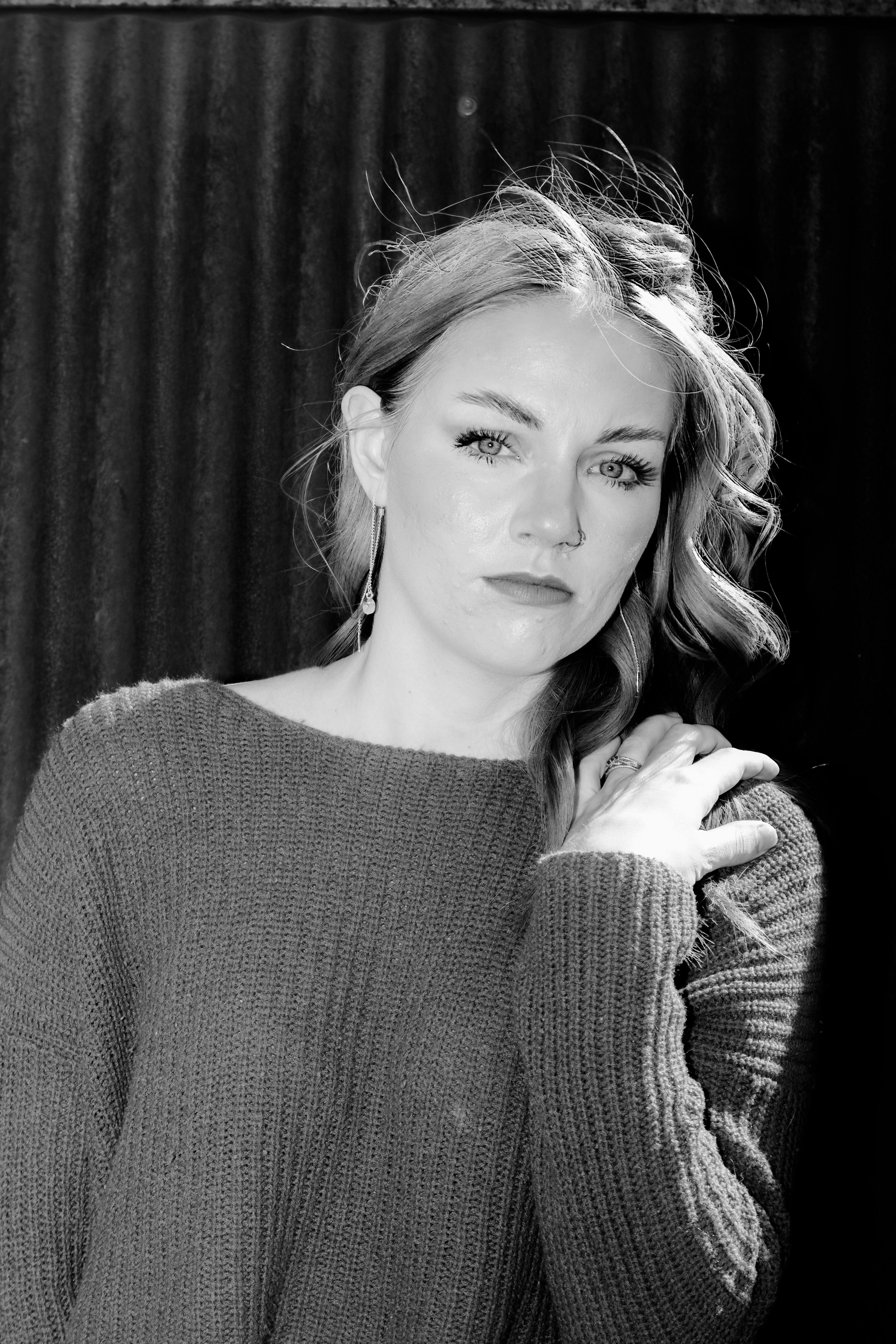 Elegant black and white portrait of a woman wearing a sweater, exuding timeless fashion style.