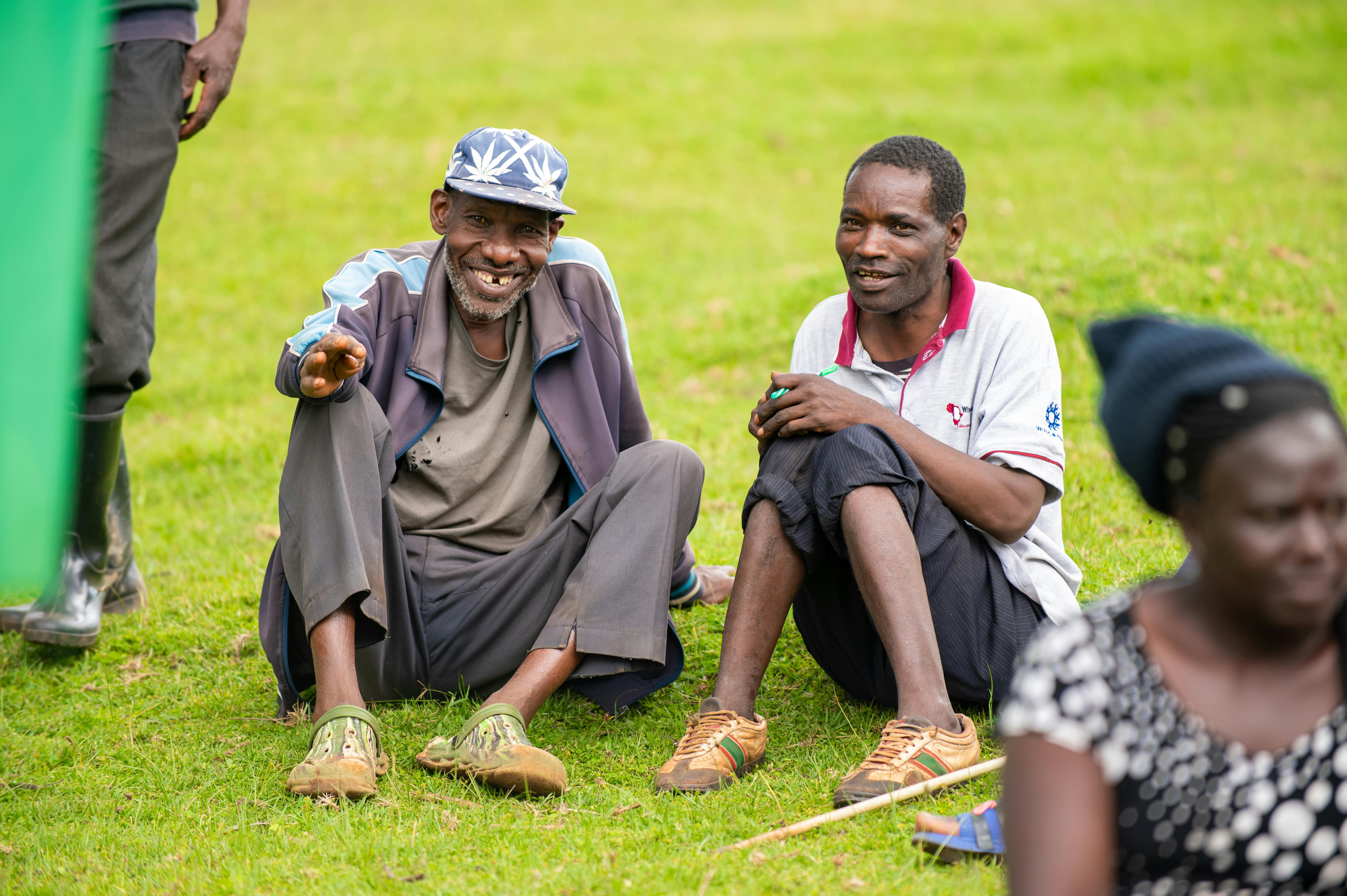 Smiling Men Sitting on Lawn · Free Stock Photo